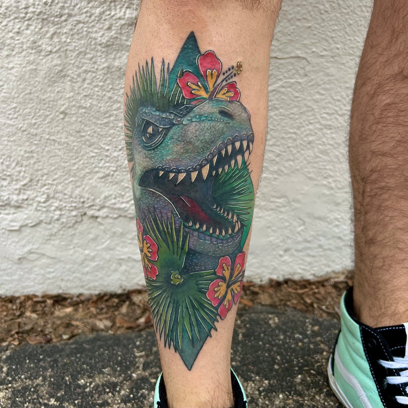 Teal and blue tyrannosaurus rex with tropical plants tattoo on a man's shin.