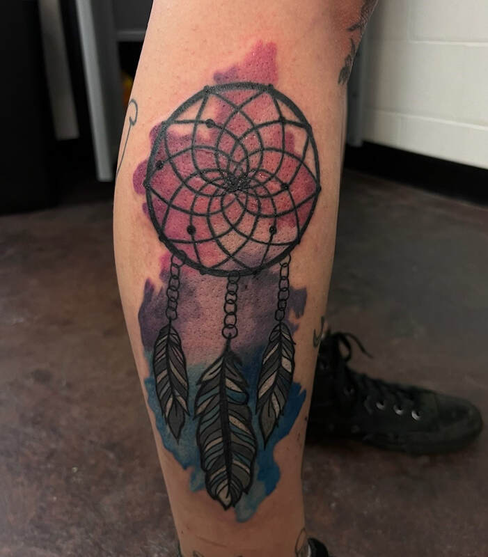 Pink, purple, and blue pansexual pride watercolor dreamcatcher tattoo on a leg.