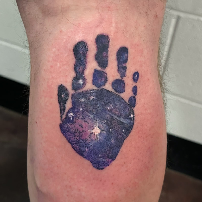 Purple galaxy hand print color realism tattoo.